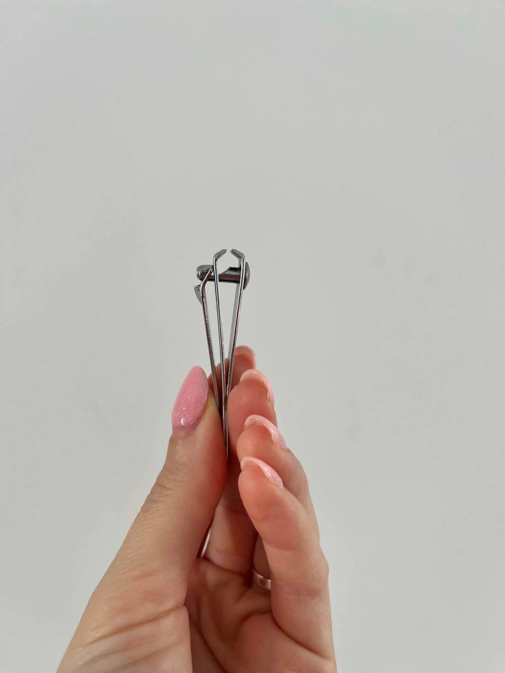 Nagelscheren-Set im Test: Hand hält einen Nagelknipser vor einer weißen Wand.