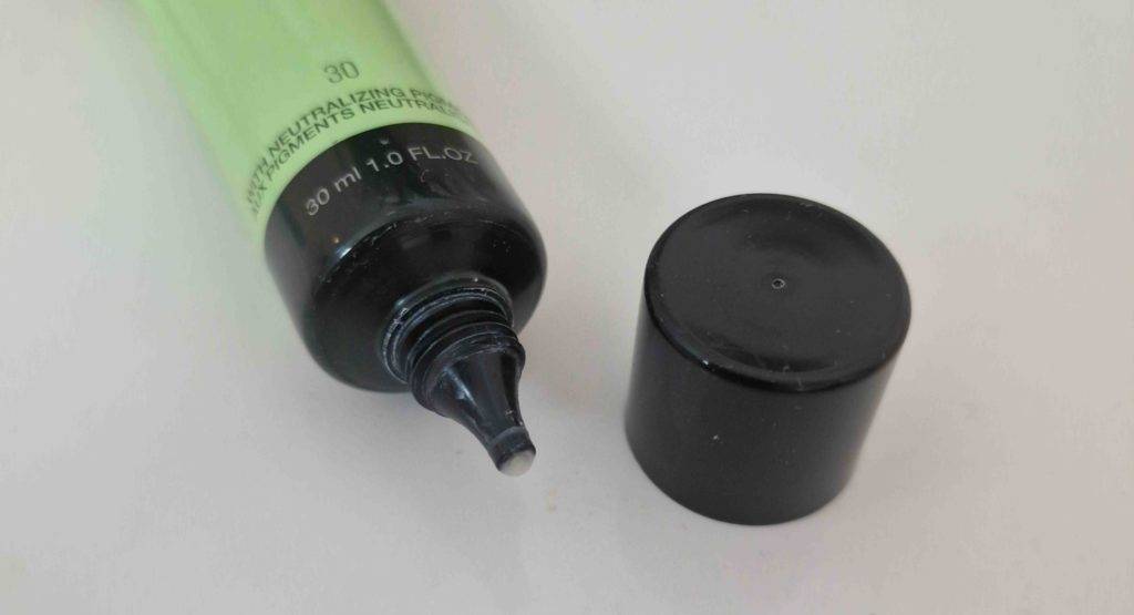 Detailansicht einer geöffneten grün-schwarzen Tube Make-up-Primer im Test vor weißem Hintergrund.
