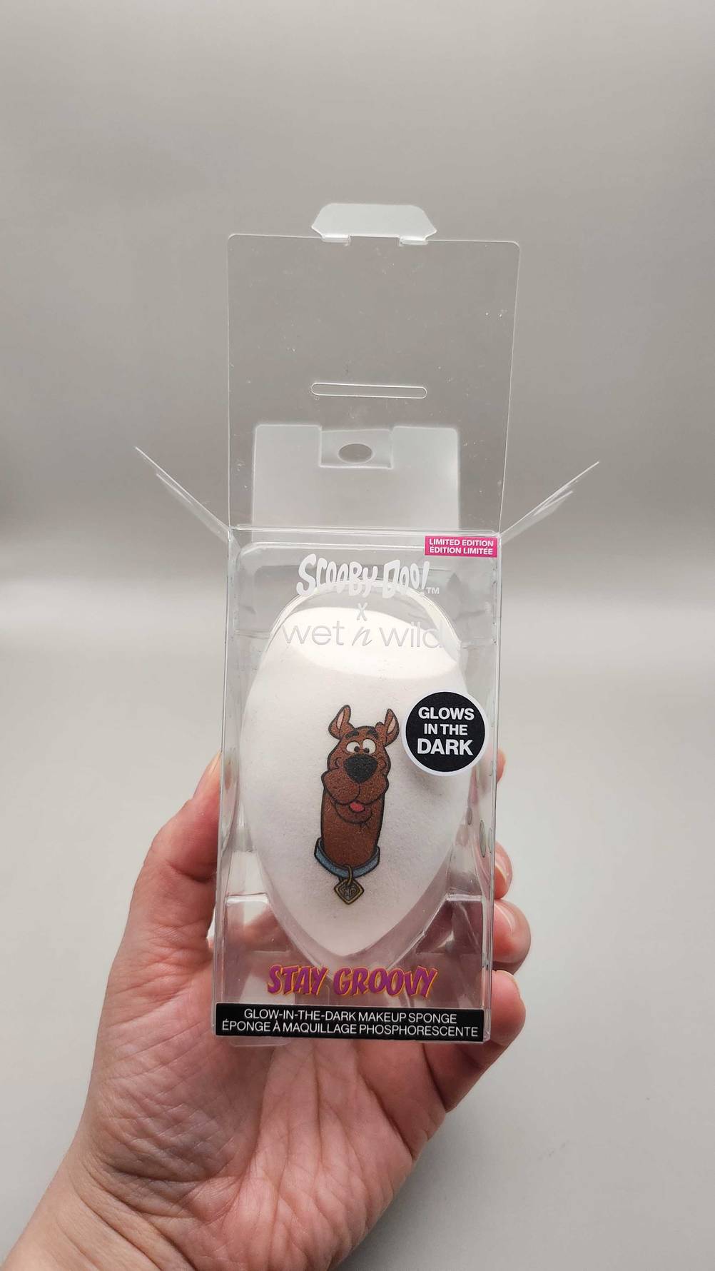 Ein getesteter Make-up-Schwamm in seiner transparenten Verpackung von einer Hand gehalten.