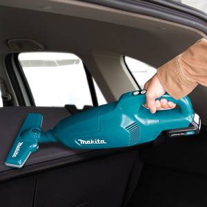 Mit einem Makita-Akku-Staubsauger wird ein Auto gesäubert.