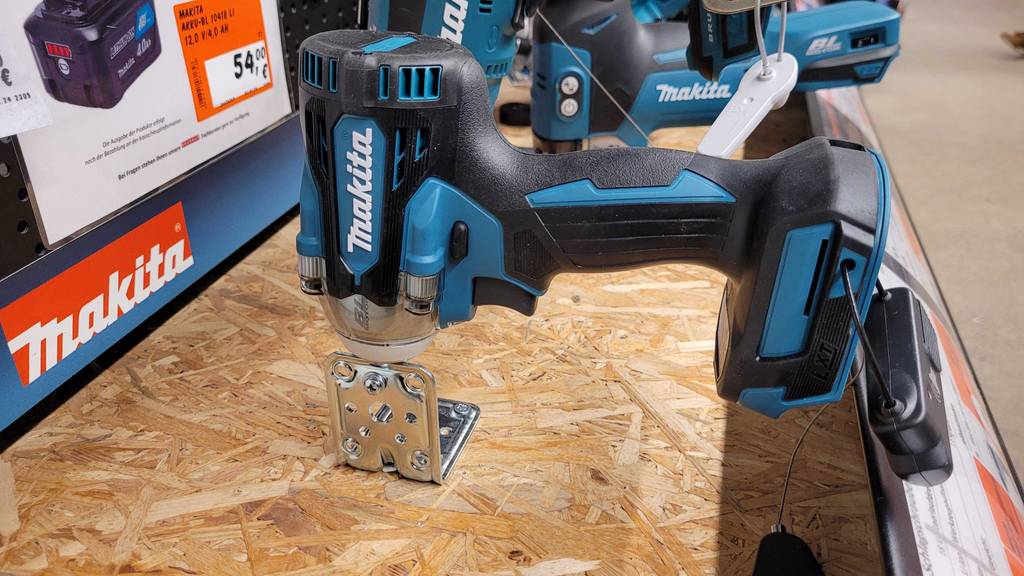 Ein Makita Schlagschrauber steht zum testen neben anderen Geräten auf einer Spanholzplatte.