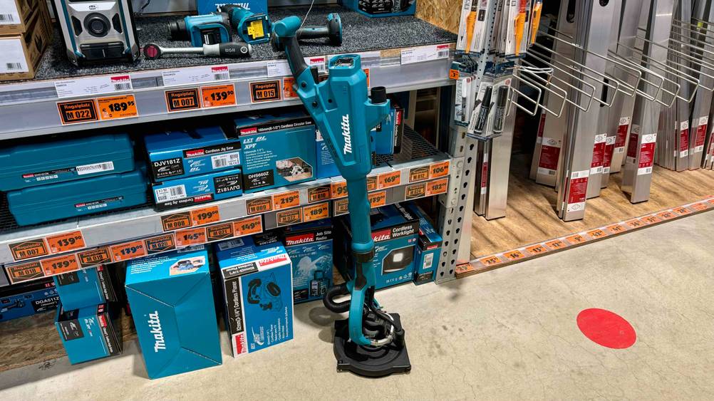 Getestet: Ein Makita-Akku-Staubsauger von der Seite vor einem Verkaufsregal mit anderen Produkten.
