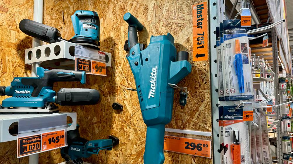 Nahaufnahme des Motors und Griffes des getesteten Makita-Akku-Staubsaugers an der Wand in einem Verkaufsregal hängend.