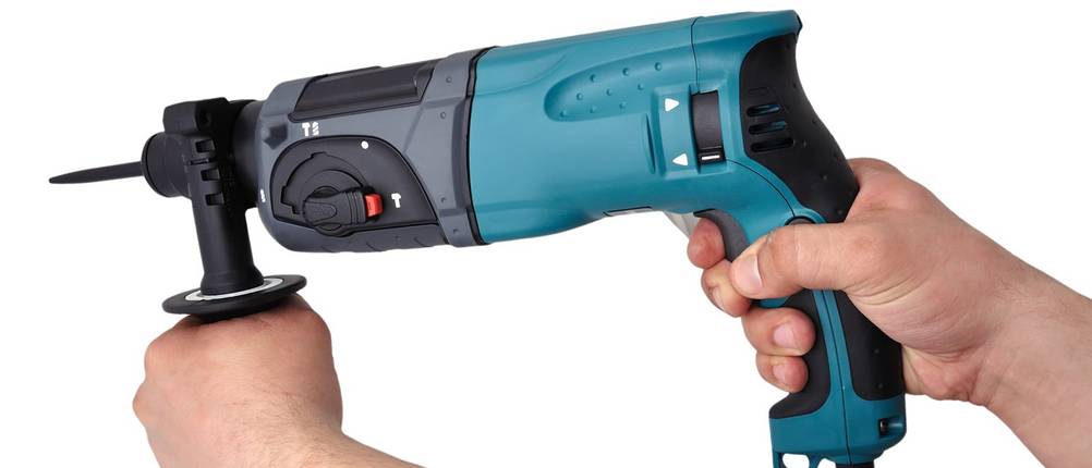Zwei Hände halten einen Bohrhammer von Makita