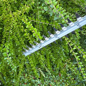 Das Scherblatt der Makita DUH523Z während dem Schneiden.