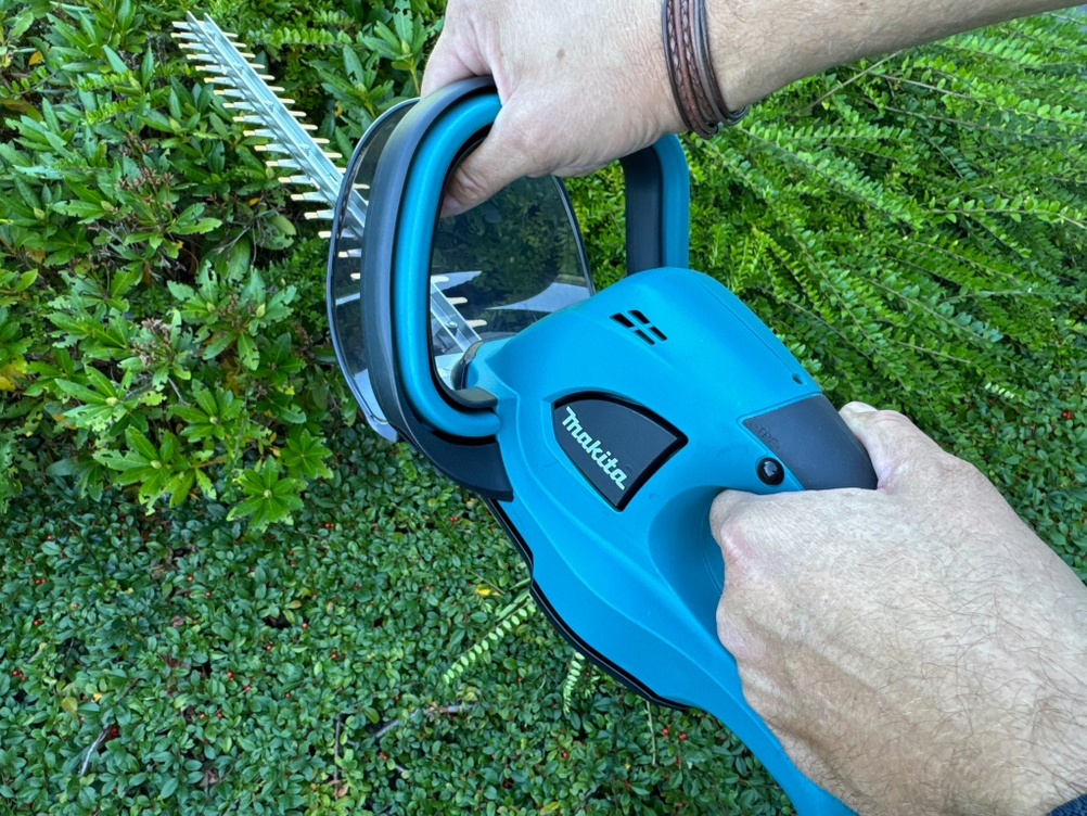 Die Makita DUH523Z wird während der Anwendung von zwei Händen festgehalten.