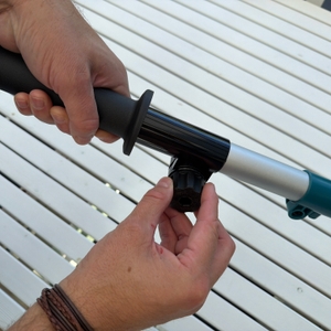 Eine Hand dreht ein Rädchen an der Makita DUN461WZ.