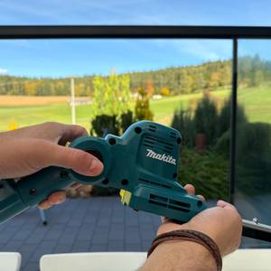 Eine Hand verändert den Winkel der Makita DUN461WZ.