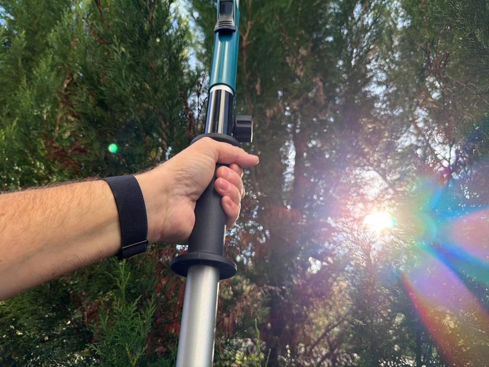 Eine Hand hält die Makita DUN461WZ am vorderen Griff fest