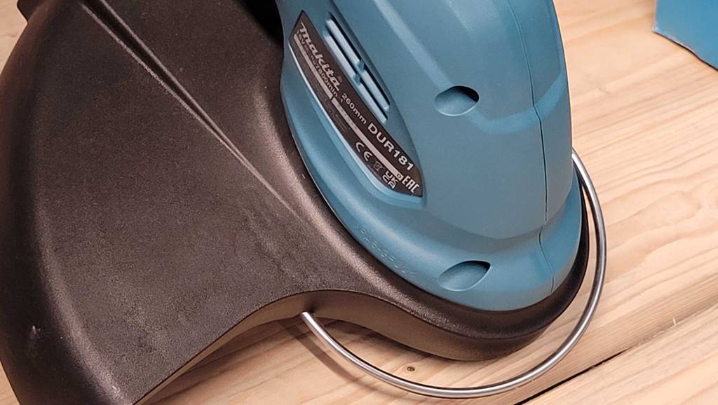 Nahaufnahme des Pflanzenschutzbügels am getesteten Akku-Rasentrimmer mit Fadensystem der Marke Makita.