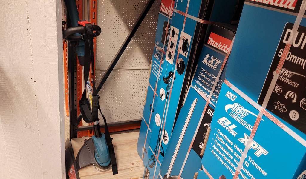 Gesamtansicht eines getesteten Akku-Rasentrimmers der Marke Makita neben seiner Originalverpackung.