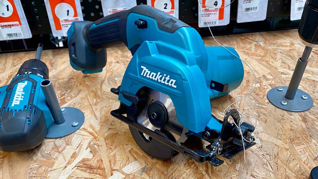 Im Test: Eine Makita Handkreissäge liegt neben anderen Produkten auf einem Holzbrett.