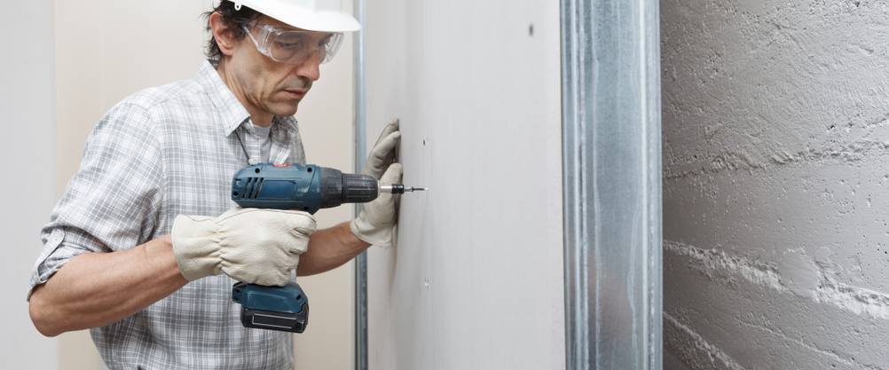 Makita-Trockenbauschrauber im Test: ein Mann arbeitet an einer Trockenbauwand mit Akku-Trockenbauschrauber.