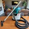 Der Makita VC2512L steht zusammen mit der Bodendüse auf einem Tisch