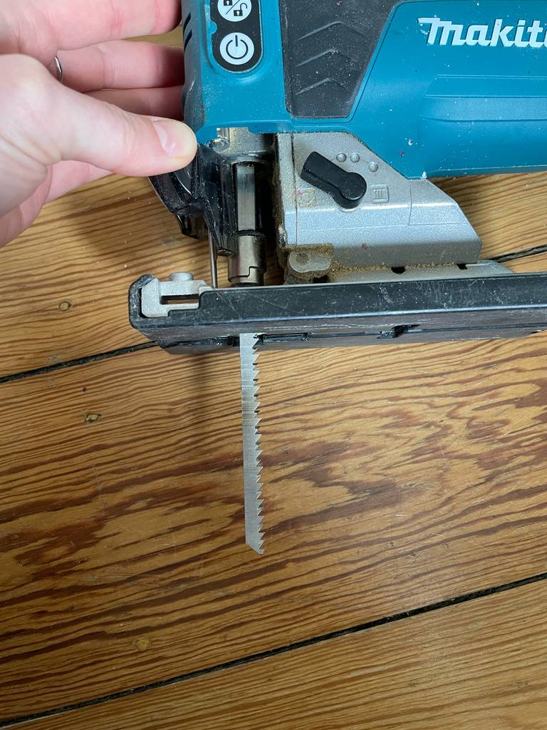 Makita-Stichsägen-Test: Eine Hand klemmt das Sägeblatt ein.