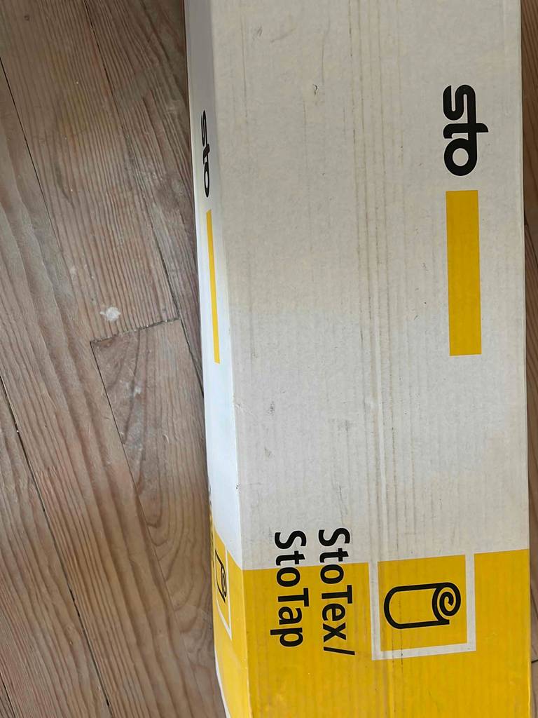 Ein getestetes Malervlies liegt verpackt auf dem Boden. 