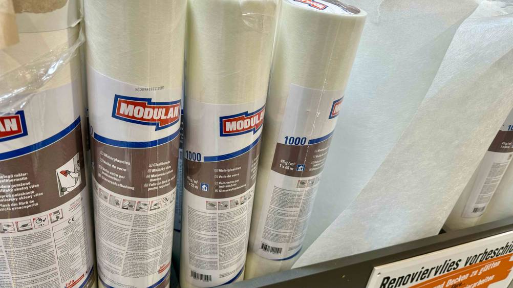Mehrere Rollen Malervlies-Tapete im Test nebeneinander in einem Verkaufsraum