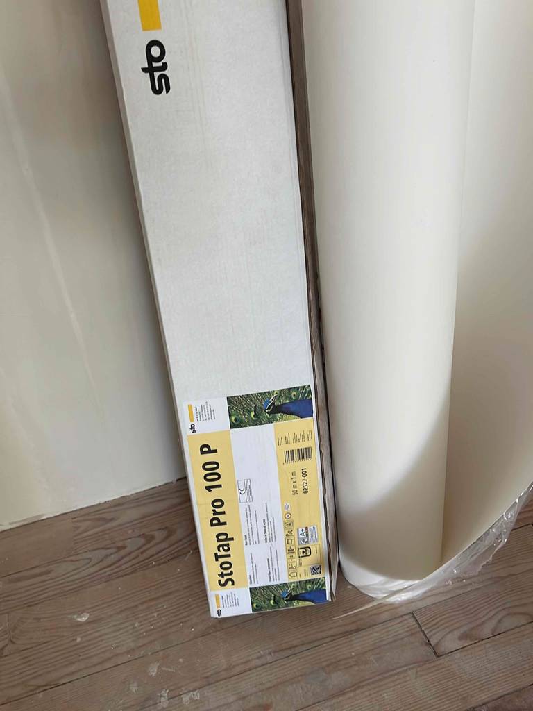 Ein getestetes Malervlies befindet sich neben der Verpackung. 