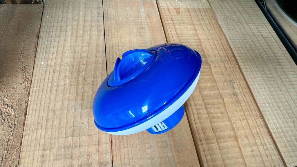 Detailansicht eines getesteten Dosierschwimmers, der auf Holzlatten liegt.