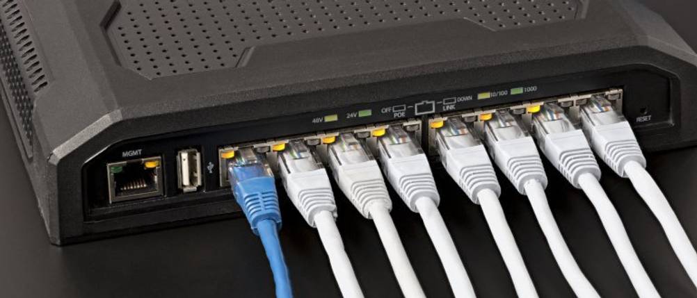 Acht getestete 15-m-LAN-Kabel stecken in einem schwarzen Router.