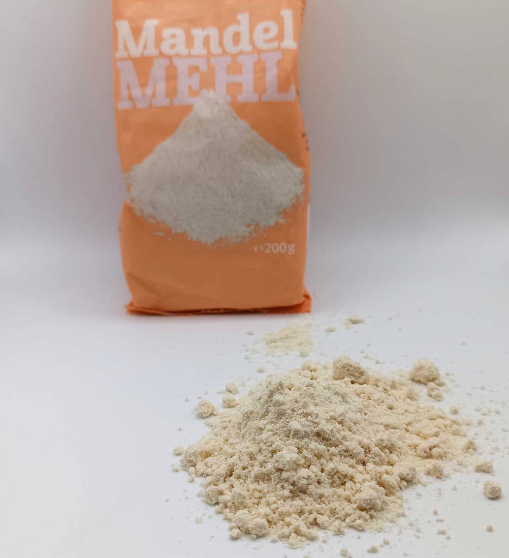 Getestetes Mandelmehl liegt verstreut vor der Verpackung.
