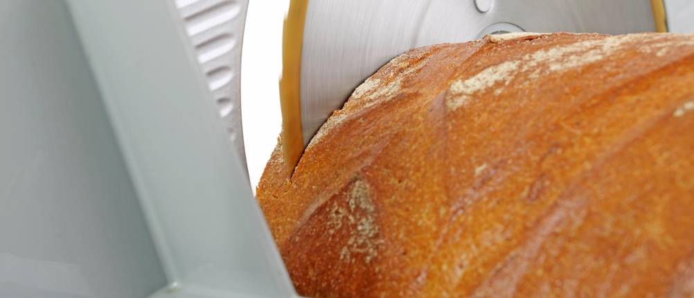 Brot in einer manuellen Brotschneidemaschine im Test.