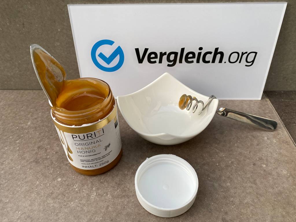 Ein getesteter Manukahonig Puriti steht mit Deckel und Schale auf einem Tisch.