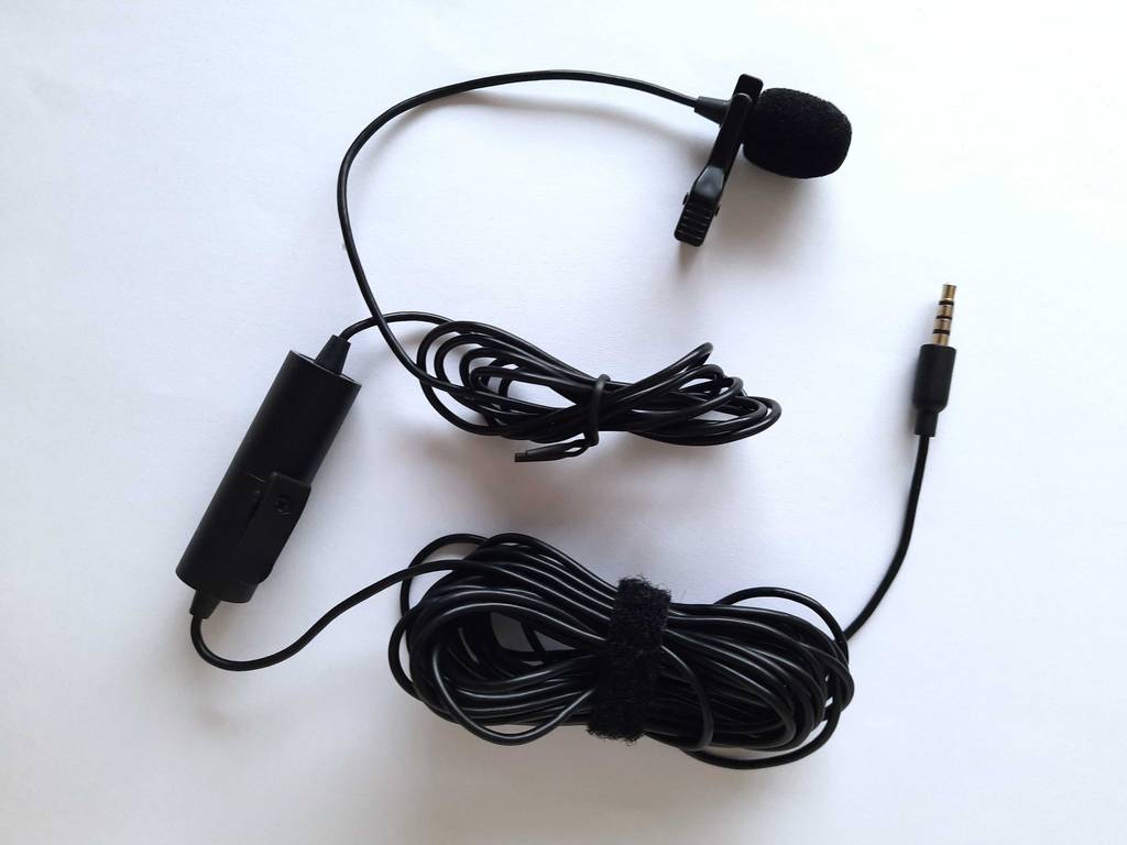 Ein getestetes Handy-Mikrofon mit aufgerollten angesteckten Kabeln von oben betrachtet.