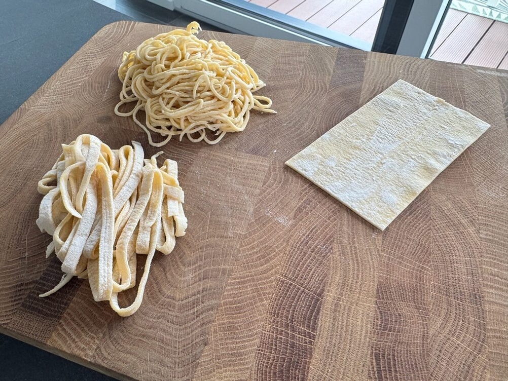 Spaghetti, Bandnudeln und ein Teiglappen aus der Marcato Classic Atlas 150 liegen auf einem Holzbrett