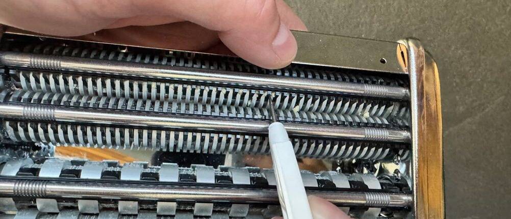 Teigreste werden aus einem Aufsatz der Marcato Classic Atlas 150 mit einem Werkzeug entfernt
