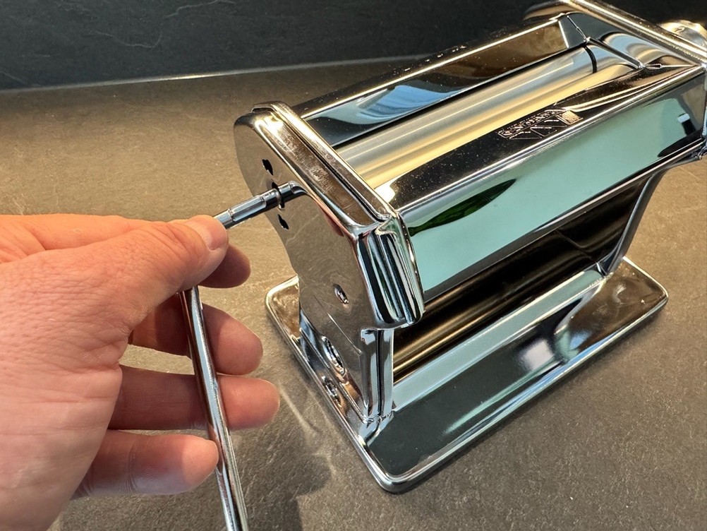 Eine Hand steckt die Kurbel der Marcato Classic Atlas 150 ein