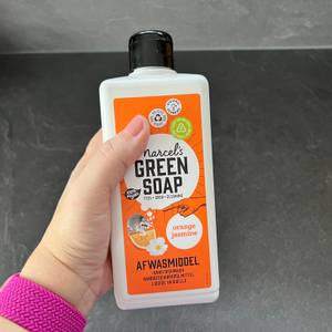 Eine Hand hält das Marcel's-Green-Soap-Spülmittel fest.