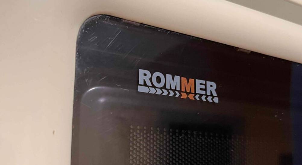 Eine ROMMER Mikrowelle ohne Grill im Test, mit dem Fokus auf das Markenzeichen.