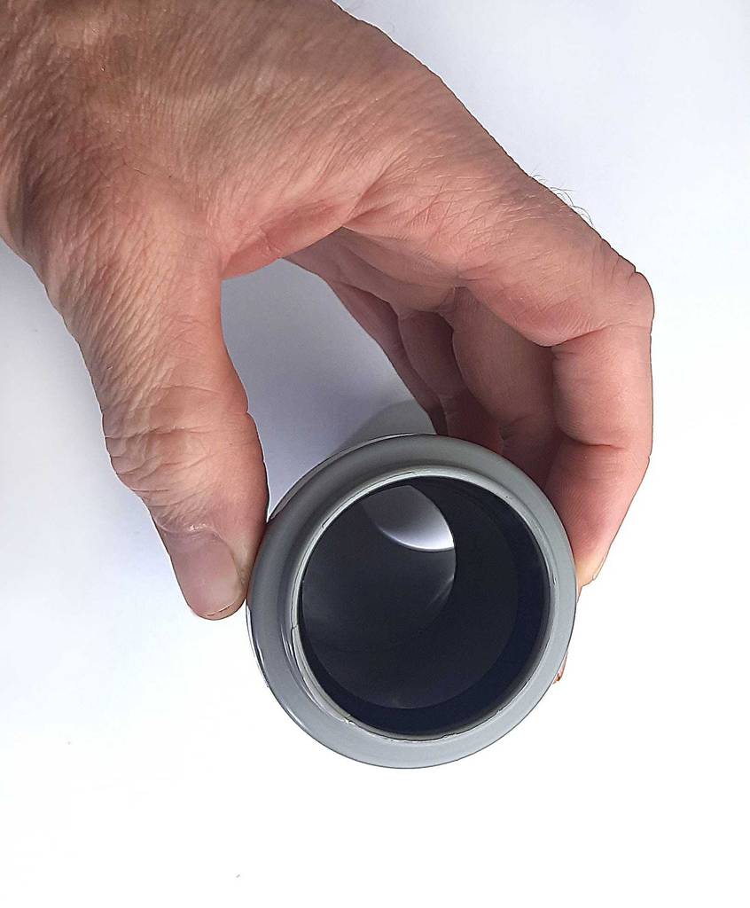 Eine Hand zeigt den Durchgang an dem grauen, angewinkelte PVC-Rohr im Test.