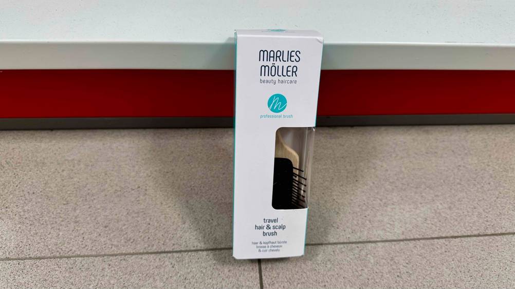 An einem Regal lehnt die Marlies-Möller-Bürste im Test in der Verpackung.
