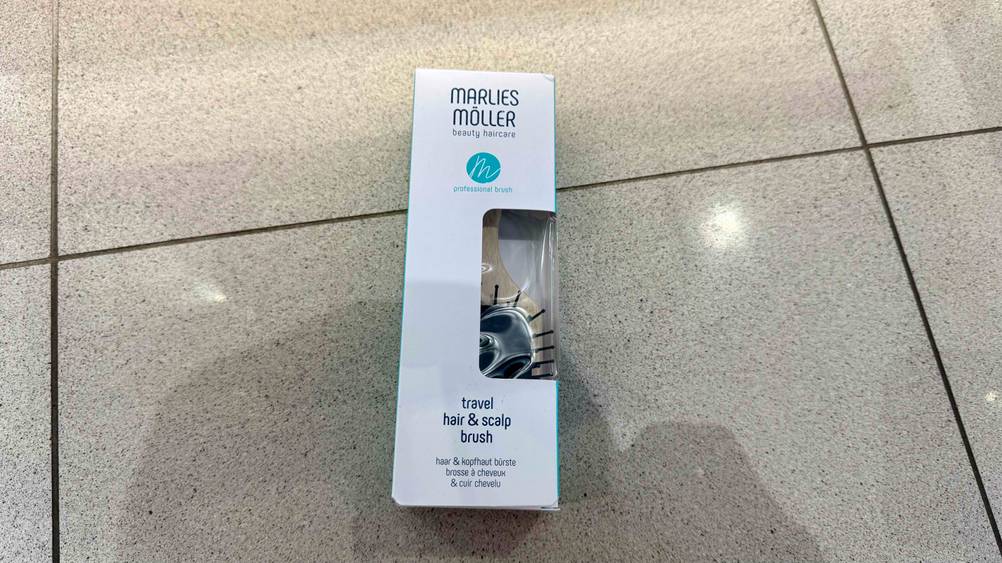 Auf dem Fließenboden liegt die getestete Marlies-Möller-Bürste in der Originalverpackung.