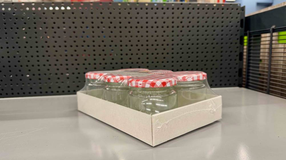 Eine Packung der getesteten Marmeladengläser von der Seite in einem Regal.