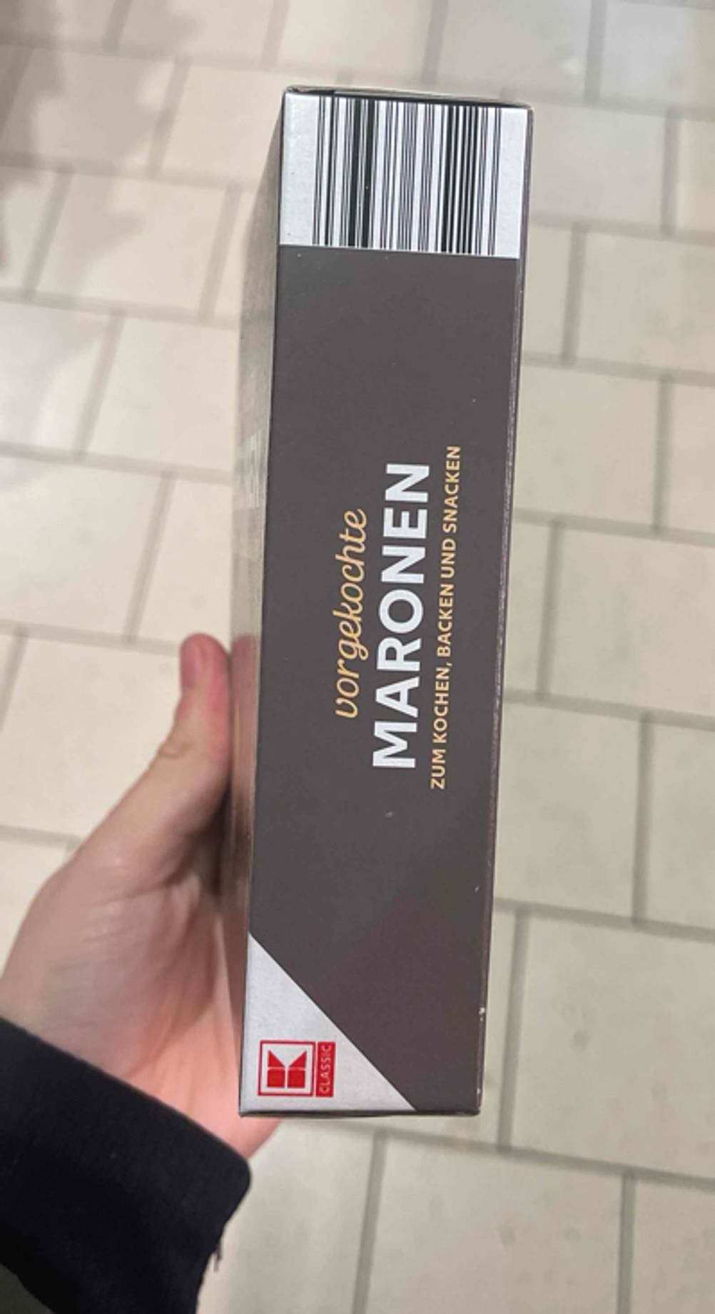 Seitenansicht einer Packung Maronen im Test von einer Hand gehalten.