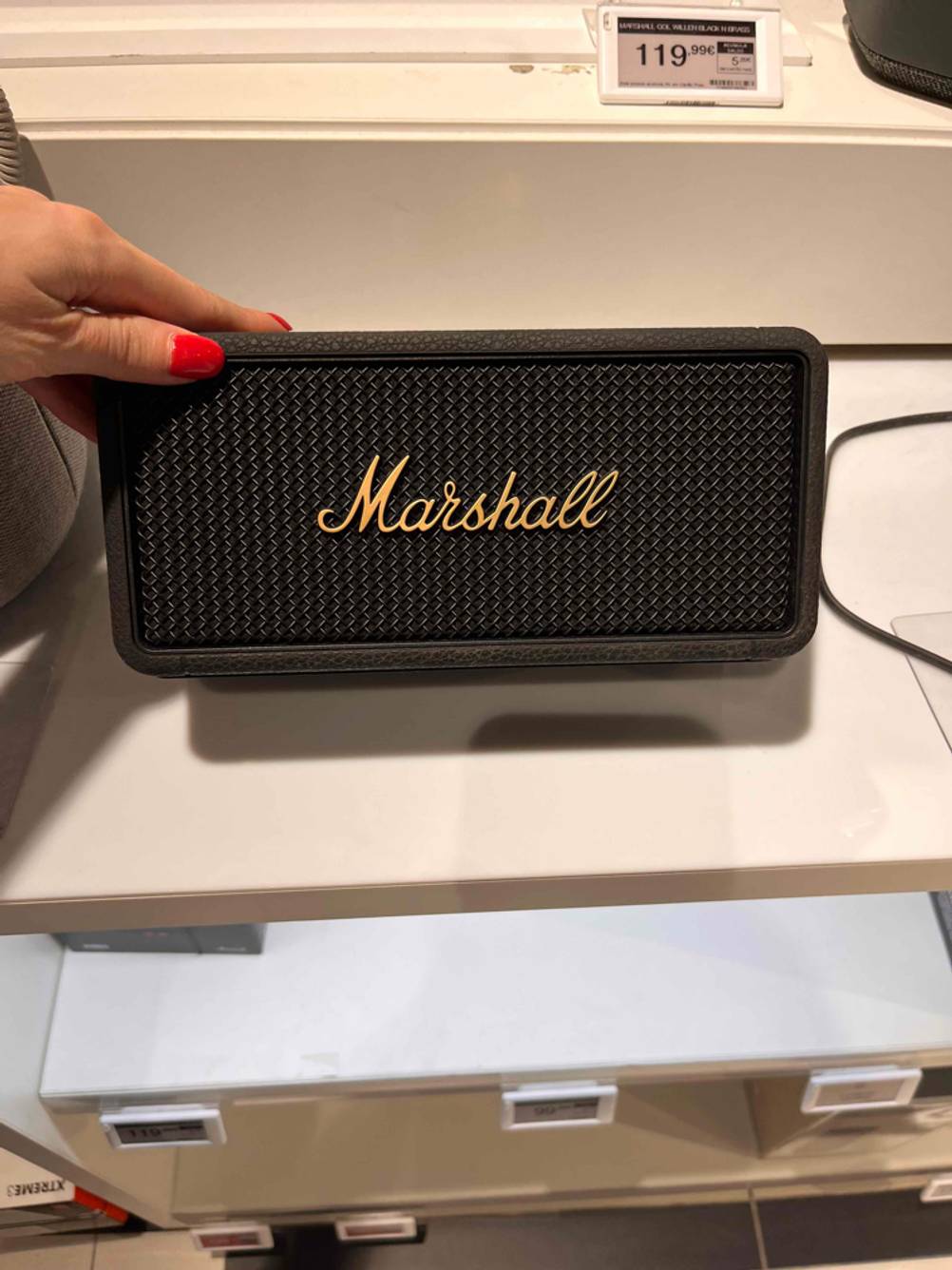 Im Test: Hand kippt einen schwarzen Marshall Bluetooth-Lautsprecher.
