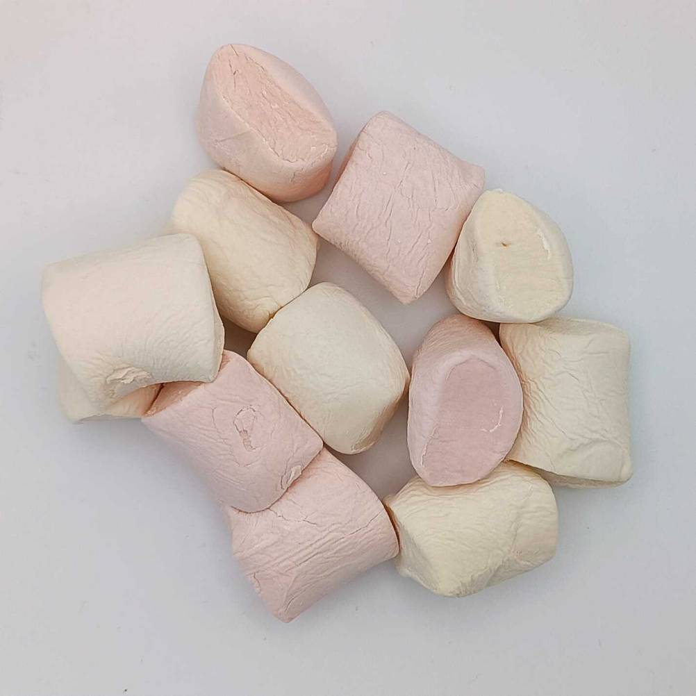 Ein paar einzelne Marshmallows im Test auf einer hellen Fläche liegend.