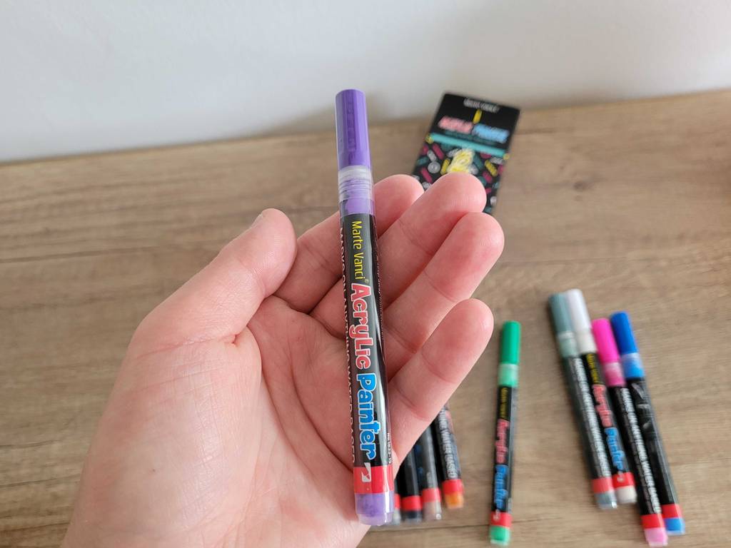Violetter Acrylstift in einer Hand