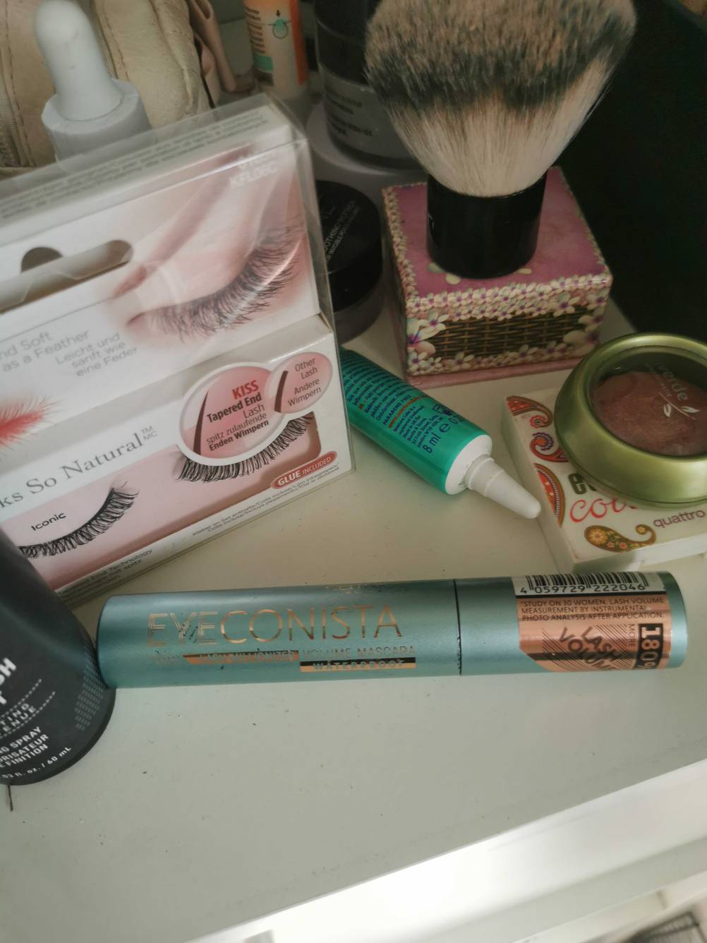 Eine getestete Mascara der Marke Catrice befindet sich zwischen anderen Make-up Produkten.
