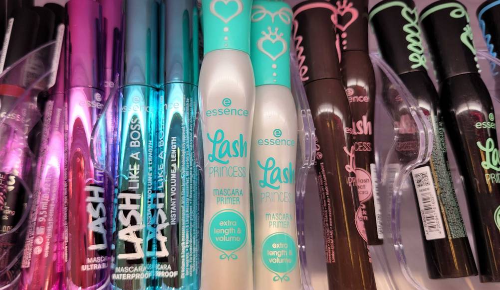 Mehrere Tuben des Mascara-Primers in einem Regal neben anderen Produkten.
