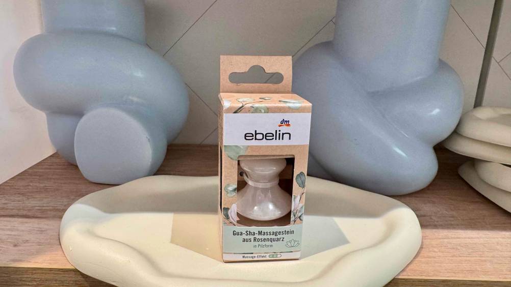 Getestet: Eine Packung Massagesteine auf einem Tabelett in einem Regal vor Vasen.