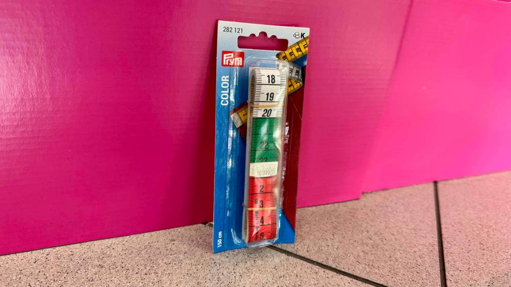 Maßband im Test: Eine Packung lehnt an einer pinken Fläche.
