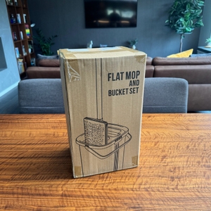 Der Karton des Masthome-Wischmopp-Sets steht auf einem Tisch.