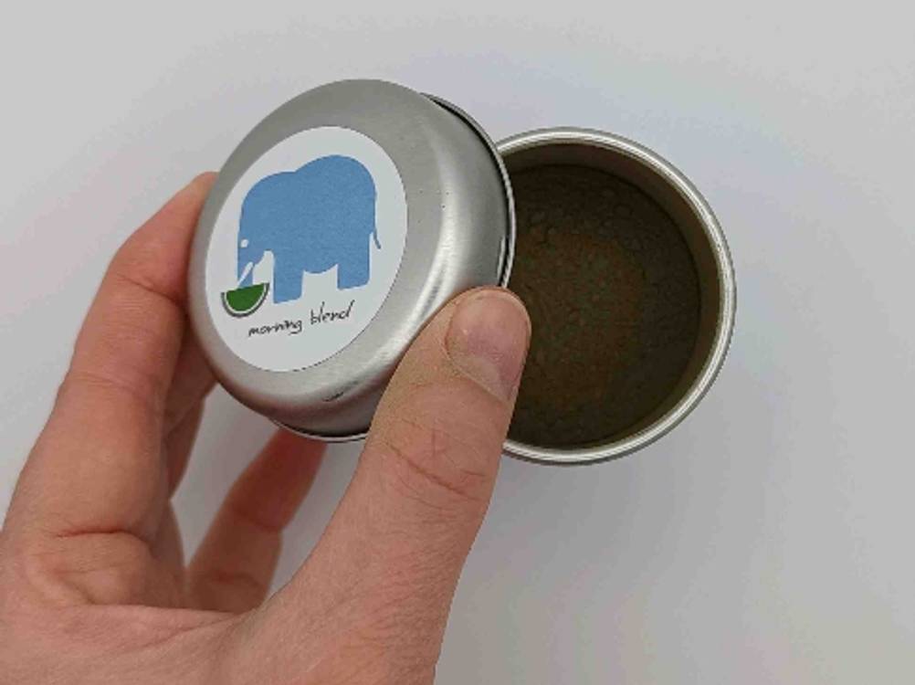 Matcha-Tee getestet: Eine Hand hält den Deckel der Dose.