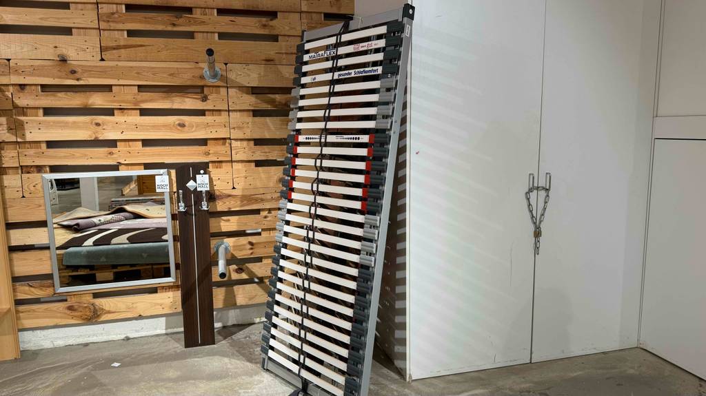 Ein getesteter Lattenrost 80x200 cm steht an einem Schrank gelehnt im Möbelhaus.