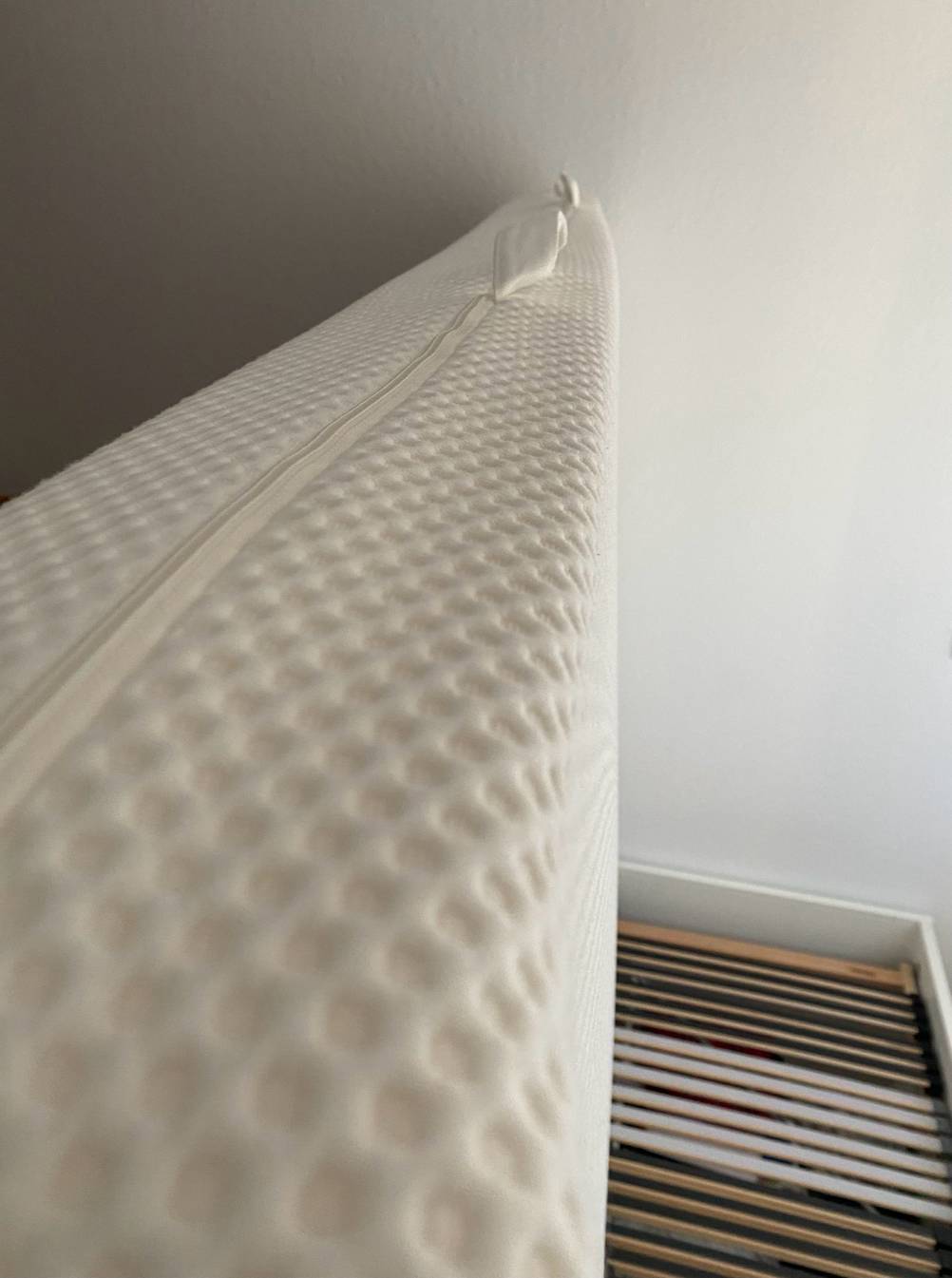 Matratze 160 x 200 cm getestet: Eine Matratze von der Seite auf einem Bett hochgehoben.