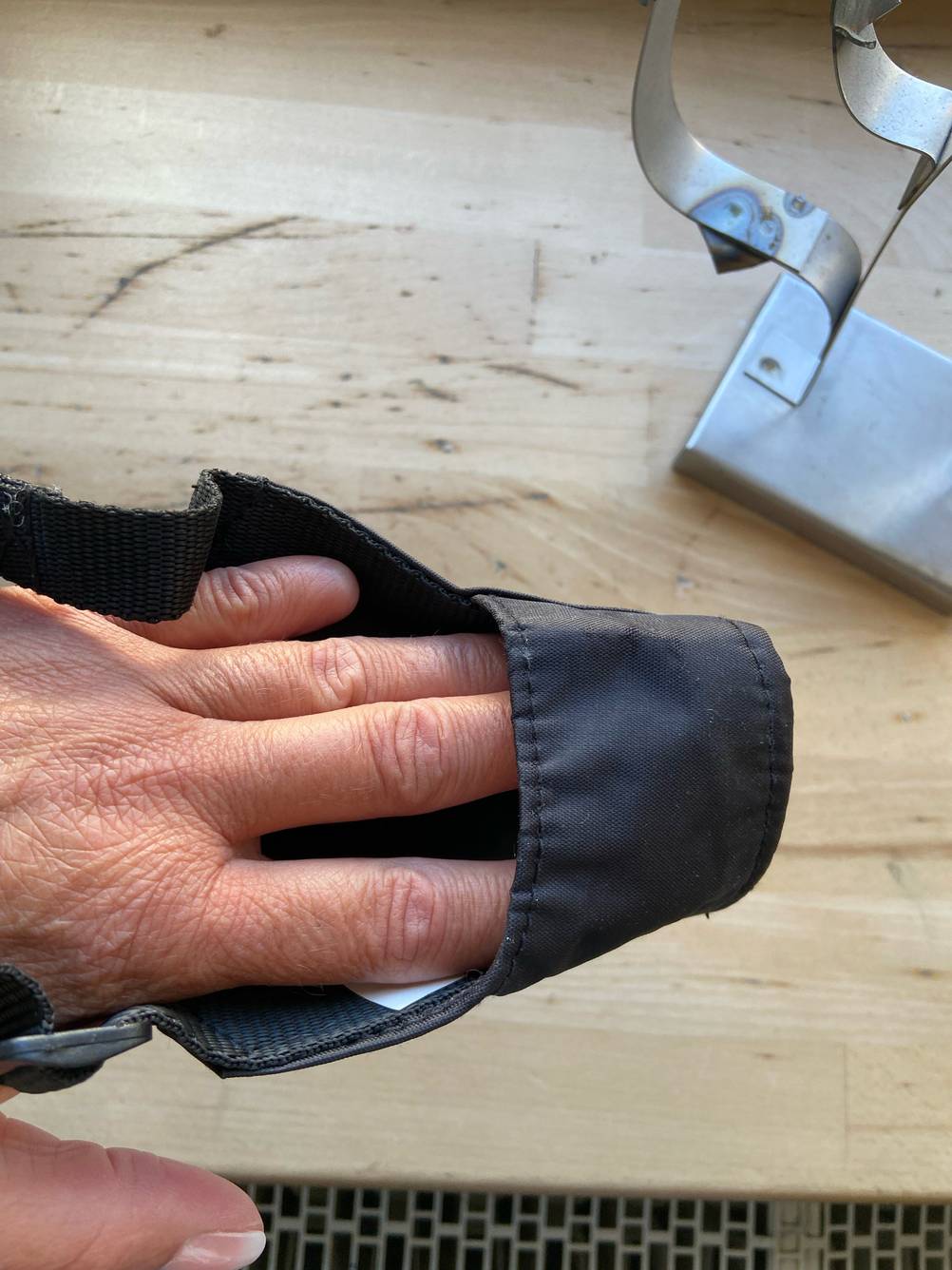 Maulkorb für Hunde im Test: Eine Hand steckt in dem Maulkorb von oben.